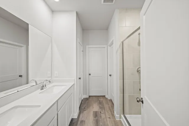 a spacious bathroom with a double vanity sink and a mirror