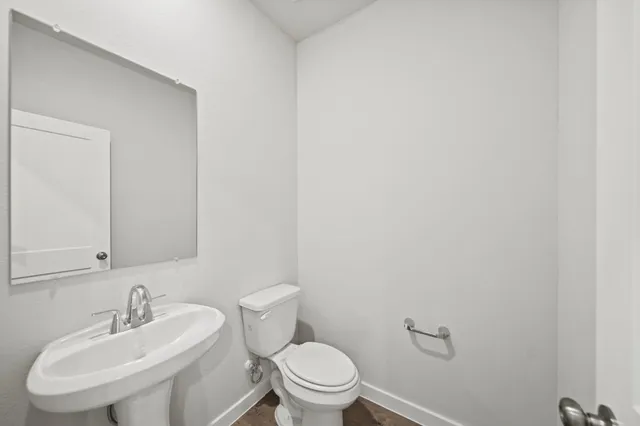 a bathroom with a sink a toilet and a mirror