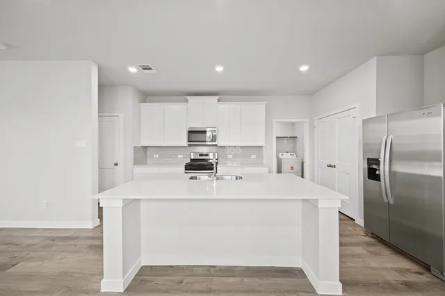 a kitchen with stainless steel appliances a refrigerator sink and microwave