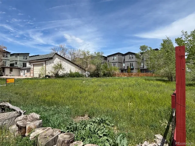 a view of a big house with a big yard and large trees