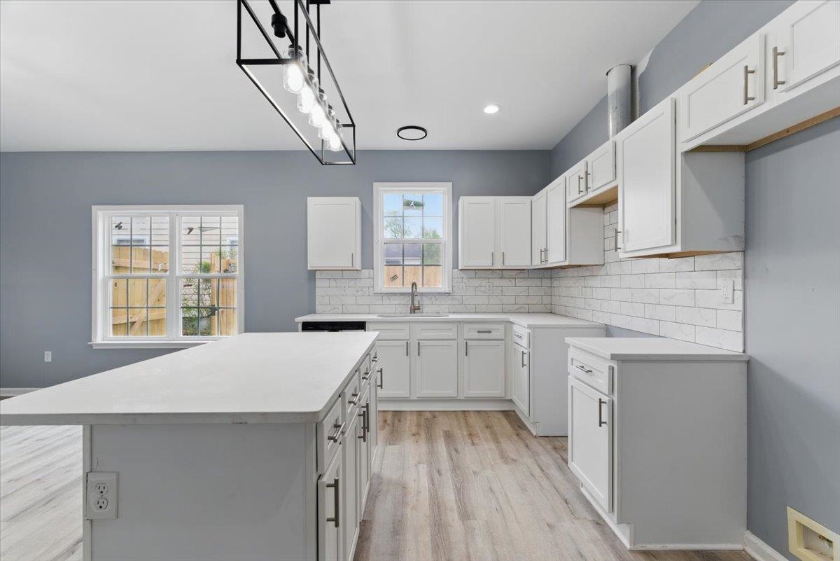 3113 Allison Avenue Memphis, TN 38112 - Photo 8 of 24 Kitchen featuring backsplash, a sink, a center island, visible vents, and light wood-style floors