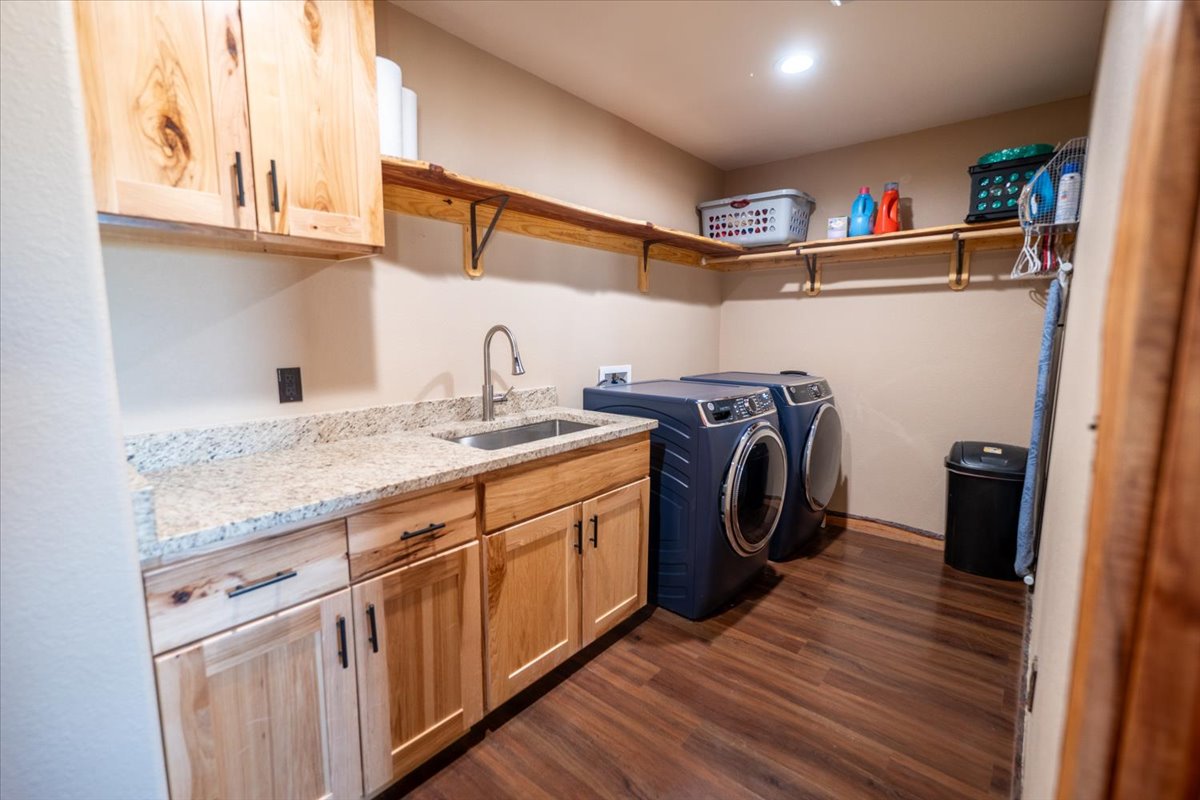 1825 Savanna Ridge Ranch Road Lometa, TX 76853 - Photo 21 of 35 Washroom featuring dark wood finished floors, washer and dryer, and cabinet space