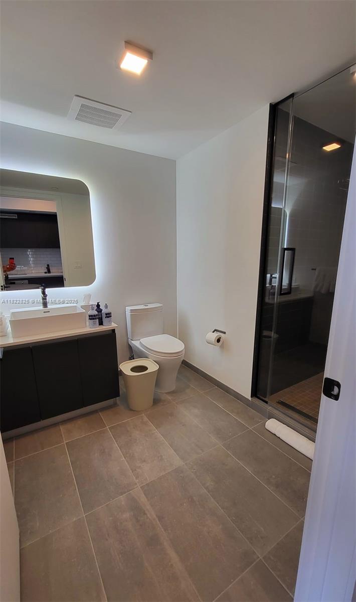 227 Northeast 2nd Street, Unit 2907 Miami, FL 33132 - Photo 11 of 36 a bathroom with a sink toilet and mirror