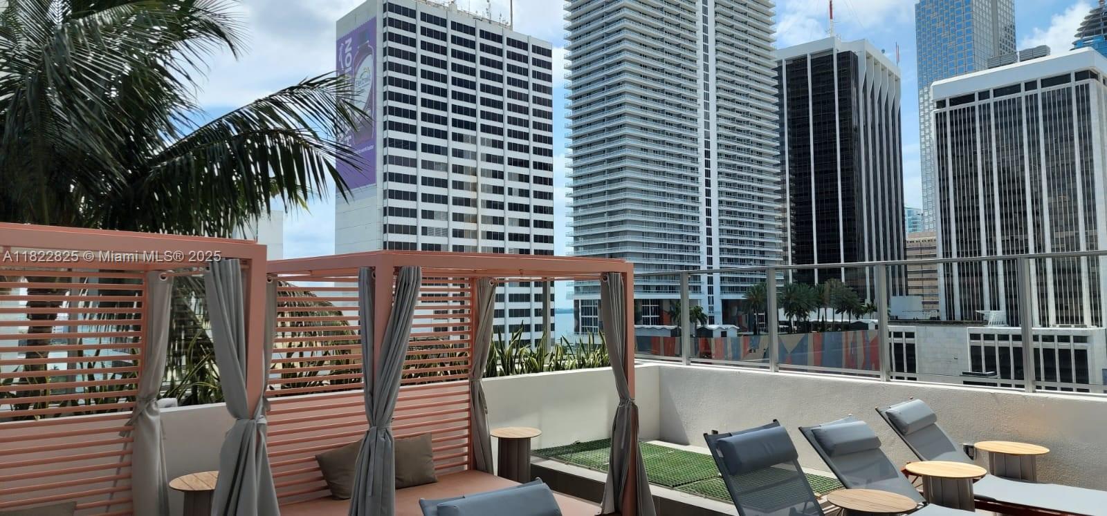 227 Northeast 2nd Street, Unit 2907 Miami, FL 33132 - Photo 17 of 36 a view of a patio with couches table and chairs and potted plants