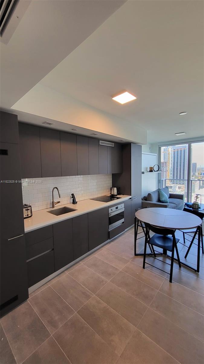 227 Northeast 2nd Street, Unit 2907 Miami, FL 33132 - Photo 6 of 36 a kitchen with a table chairs and a refrigerator