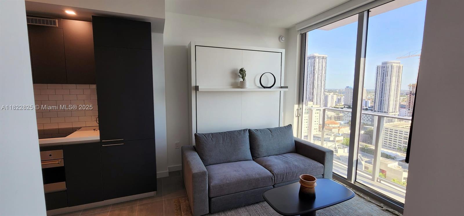 227 Northeast 2nd Street, Unit 2907 Miami, FL 33132 - Photo 7 of 36 a living room with furniture and a floor to ceiling window