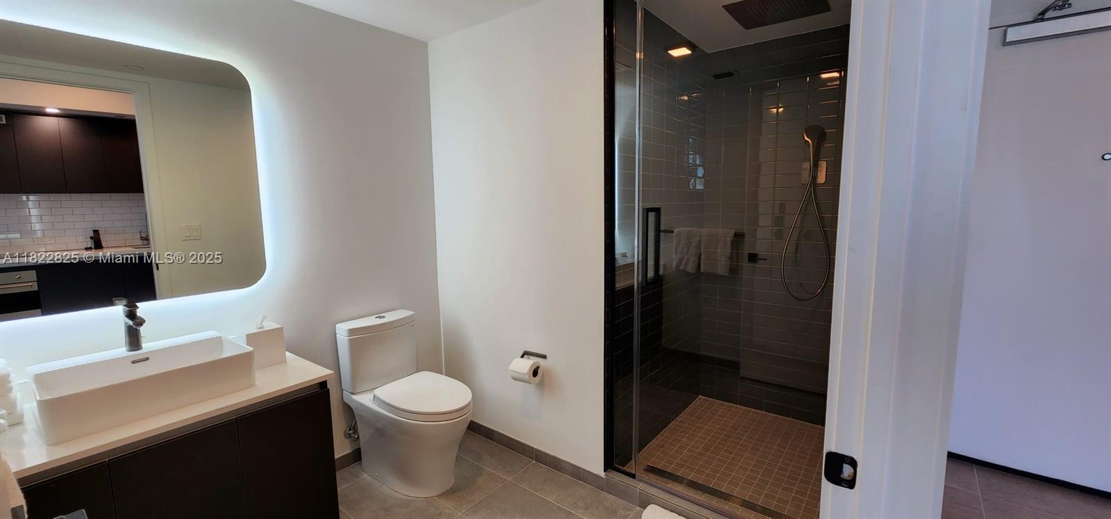 227 Northeast 2nd Street, Unit 2907 Miami, FL 33132 - Photo 9 of 36 a bathroom with a toilet a sink and mirror