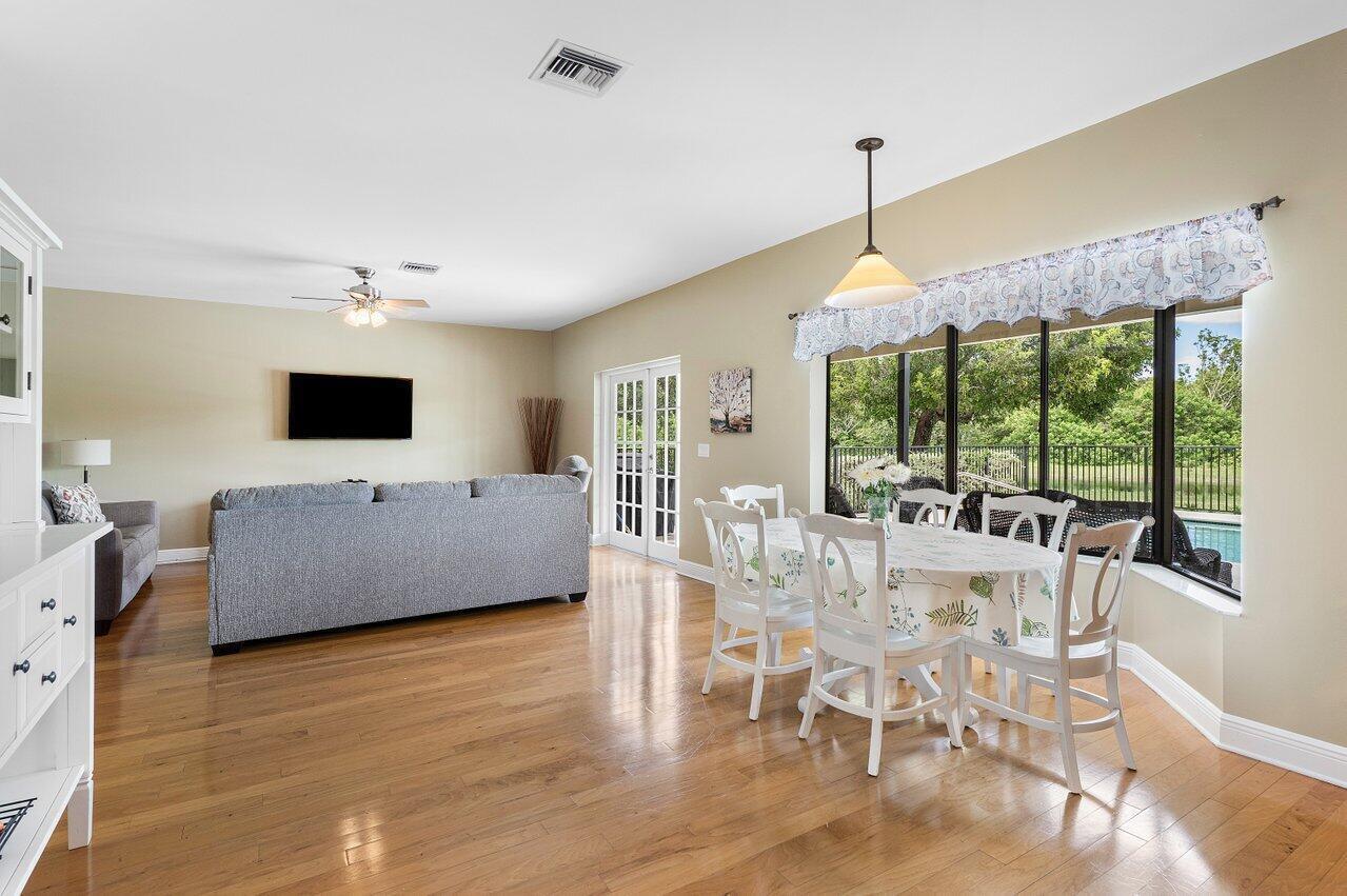 11842 Island Lakes Lane Boca Raton, FL 33498 - Photo 16 of 49 a living room with furniture a flat screen tv and a floor to ceiling window