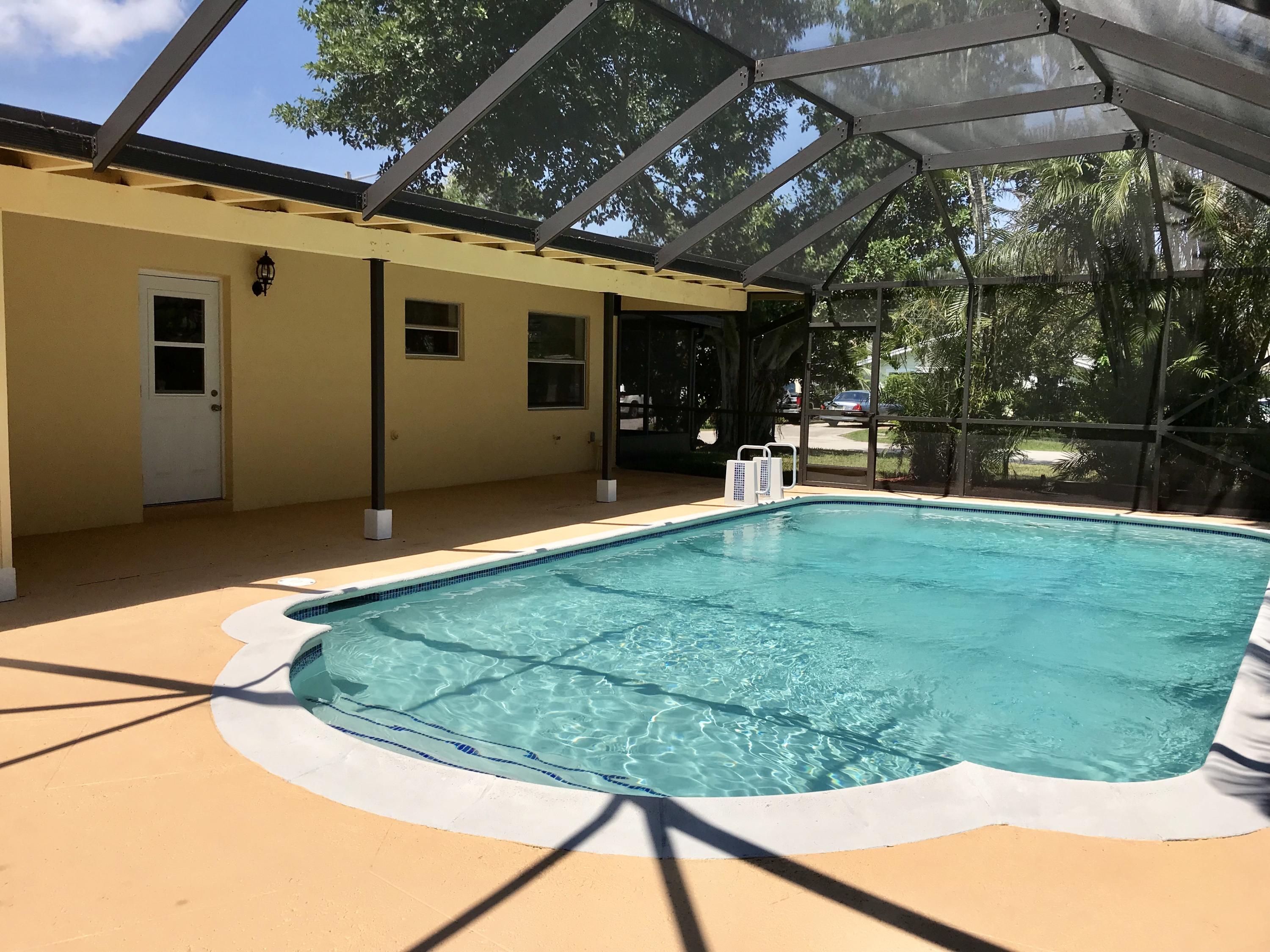 14827 Whatley Road Delray Beach, FL 33445 - Photo 15 of 36 a view of a backyard with table and chairs under an umbrella