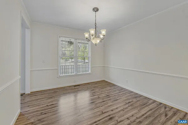 a view of a hallway with wooden floor and a ceiling fan