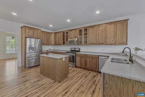 a kitchen with kitchen island granite countertop a sink cabinets and stainless steel appliances