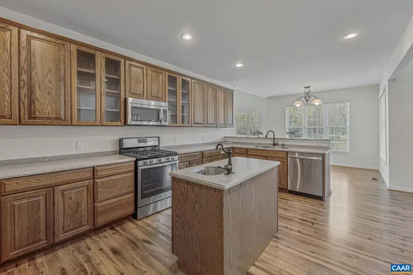 a kitchen with stainless steel appliances granite countertop wooden cabinets sink and stove top oven