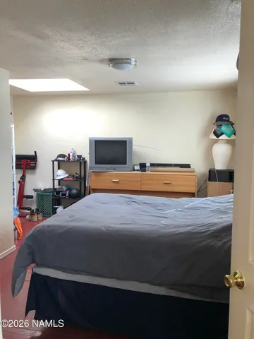 a bedroom with furniture and a flat screen tv