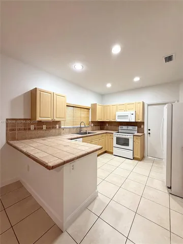 a kitchen with stainless steel appliances kitchen island granite countertop a sink and cabinets