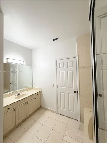 a spacious bathroom with a double vanity sink a mirror and a shower