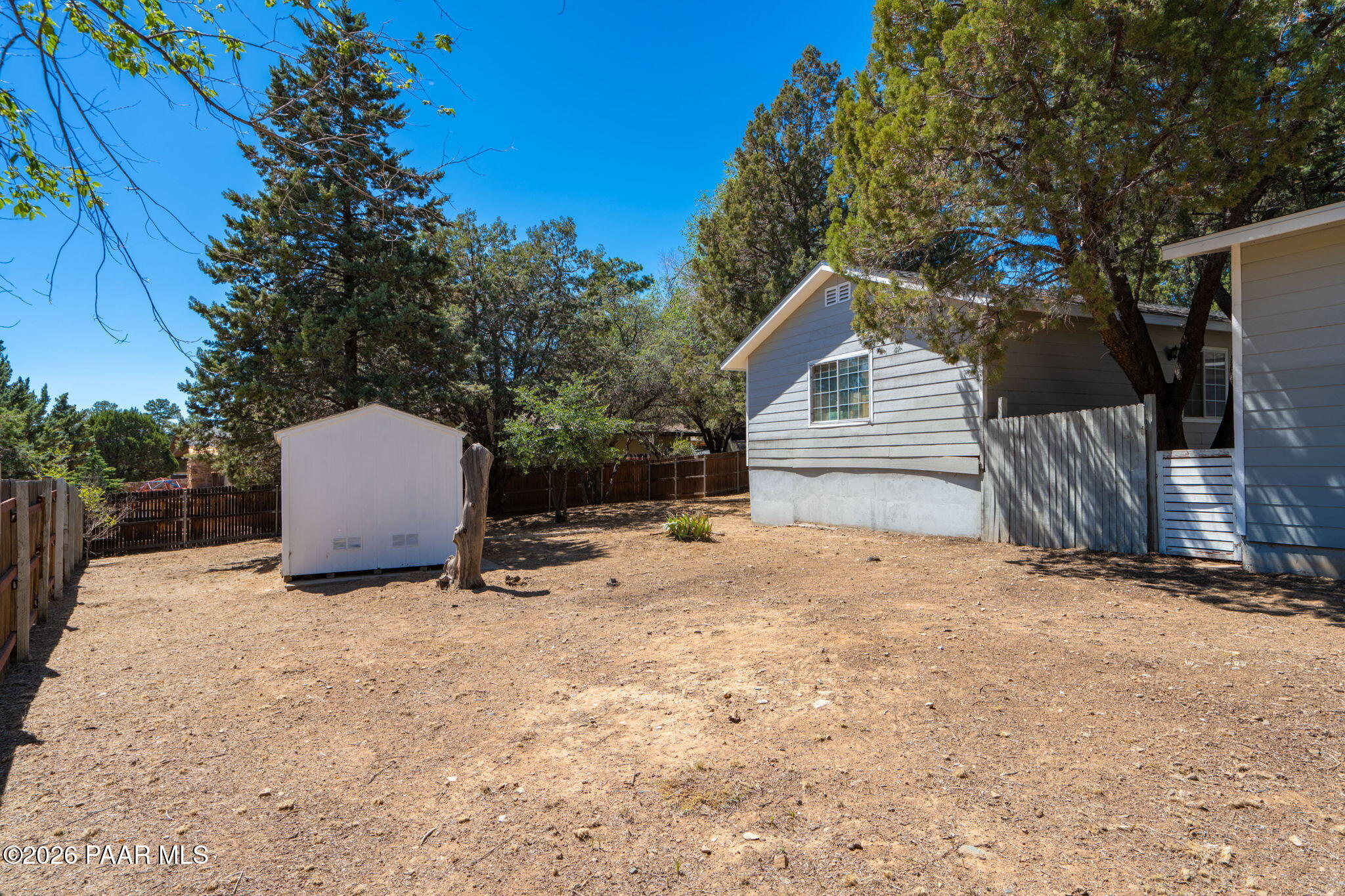 1710 Grandview Road Prescott, AZ 86305 - Photo 28 of 47 a backyard of a house with wooden fence and a tree