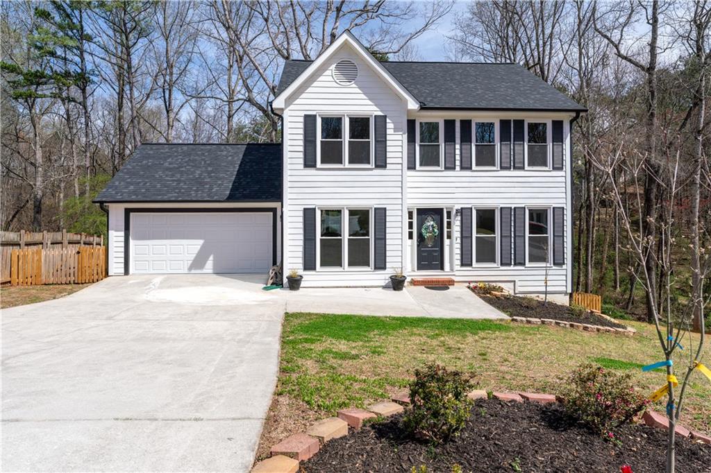 a front view of a house with yard and green space