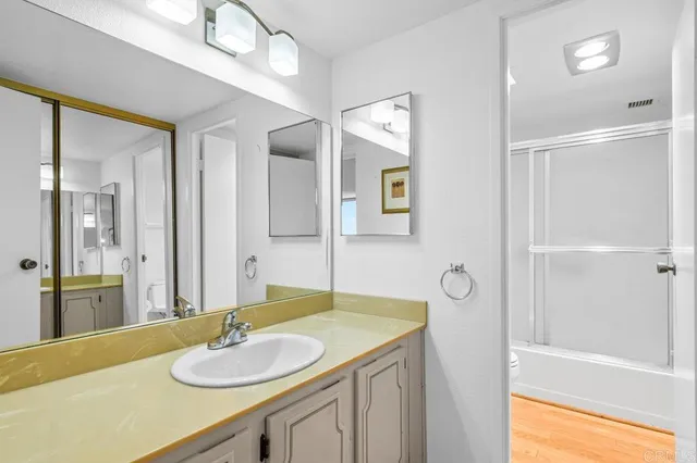 a bathroom with a granite countertop sink and a mirror