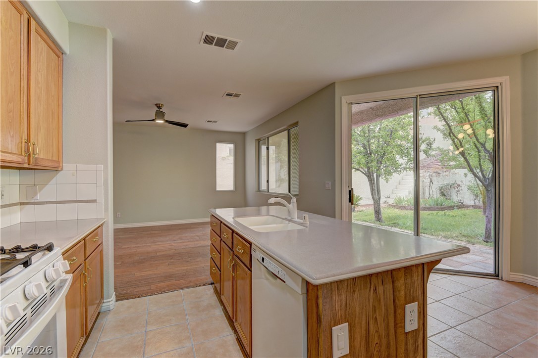 1813 Snow Spring Lane Las Vegas, NV 89134 - Photo 11 of 37 A functional kitchen island anchors this open-concept space, offering views of the private yard through sliding glass doors.