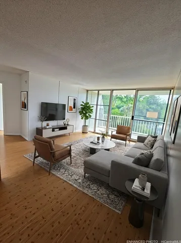 a living room with furniture a flat screen tv and a large window