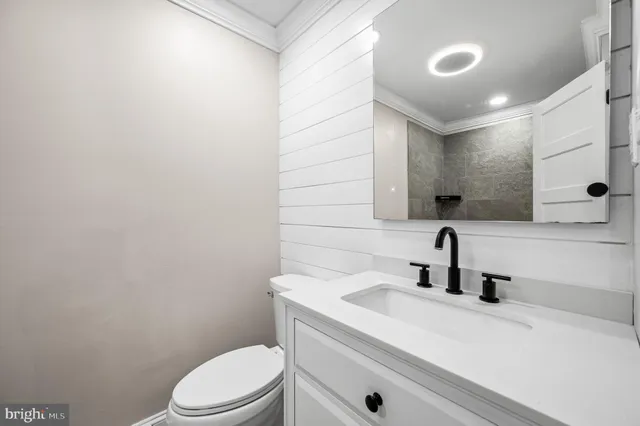 a bathroom with a sink a toilet and mirror