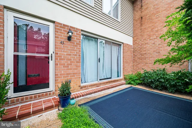 a backyard of a house with potted plants and wooden fence