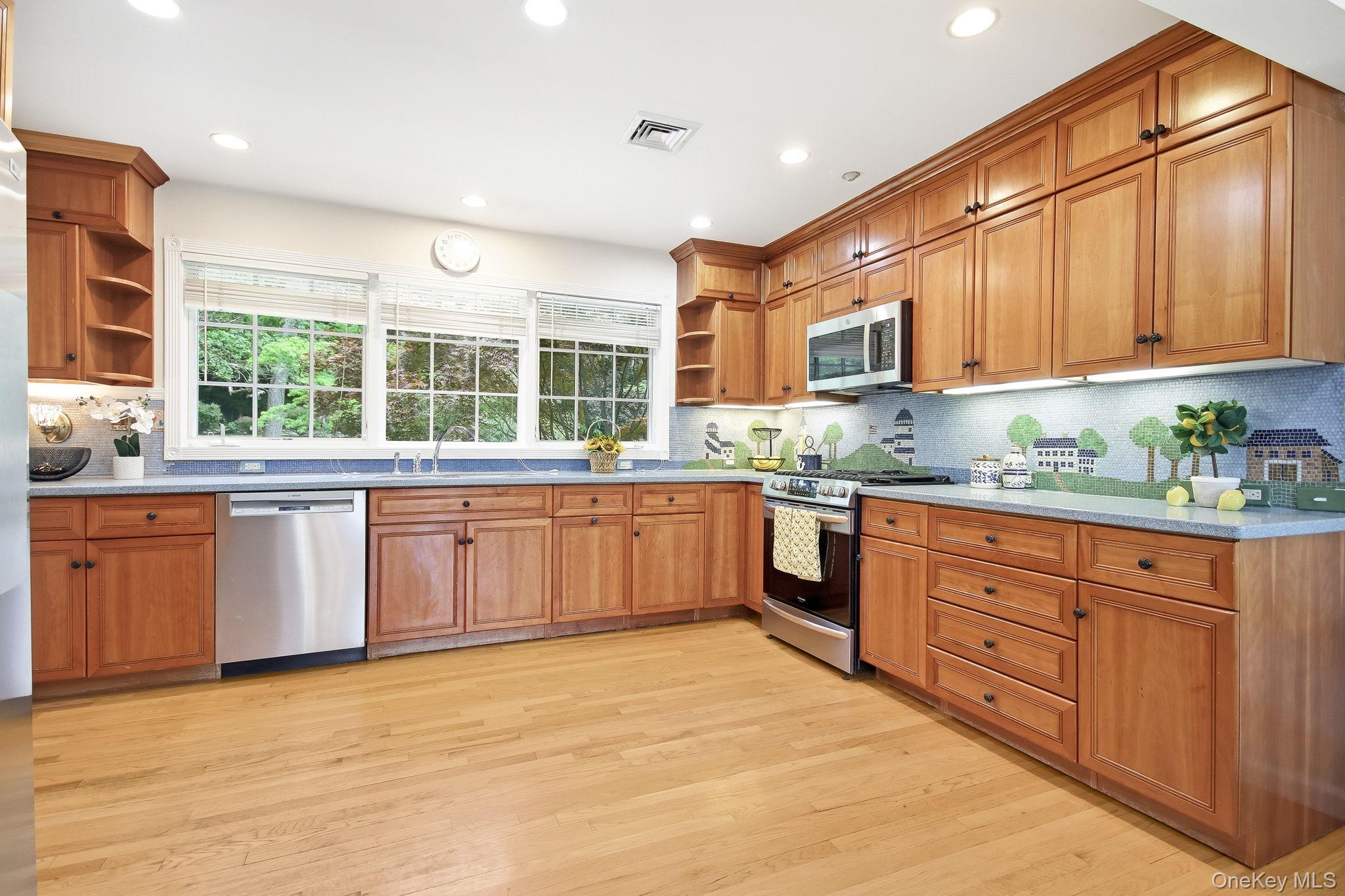 26 Century Ridge Road Purchase, NY 10577 - Photo 11 of 50 Kitchen featuring wood cabinetry, stainless steel appliances, hardwood flooring, recessed lighting, and a window overlooking exterior greenery