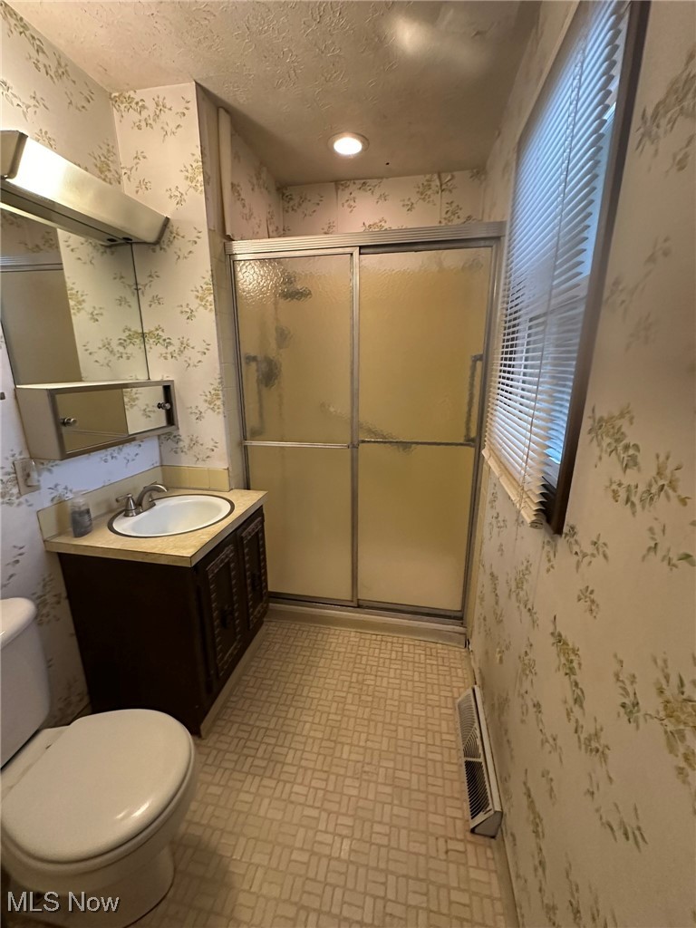 97 West Howe Road Tallmadge, OH 44278 - Photo 34 of 35 Bathroom with vanity, a shower with shower door, toilet, and a textured ceiling