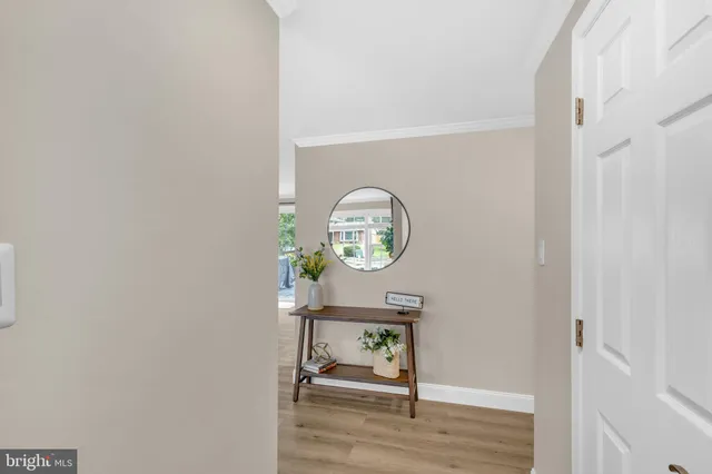 a view of a hallway with wooden floor table and chair