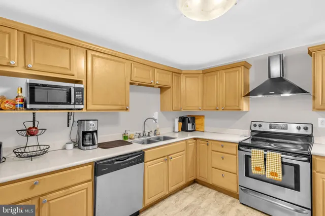 a kitchen with stainless steel appliances a sink cabinets and a window