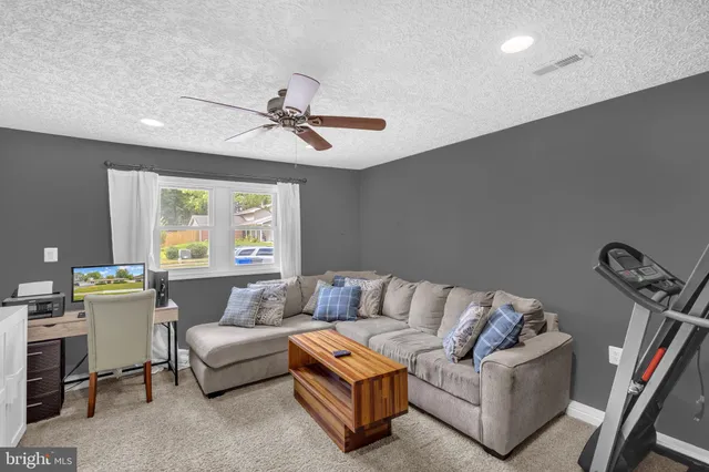 a living room with furniture and a ceiling fan