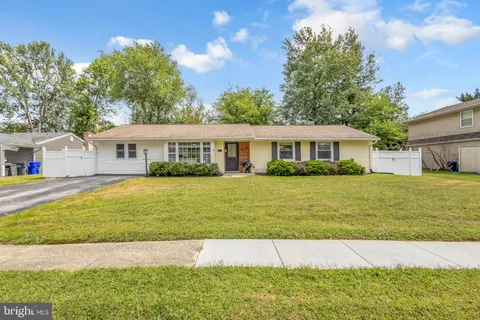a view of a white house with a swimming pool and a yard