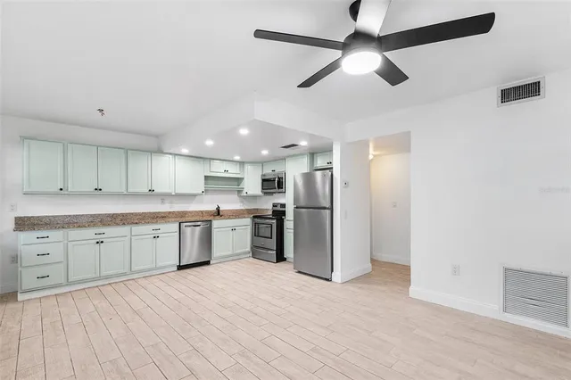 a large kitchen with a refrigerator and a sink