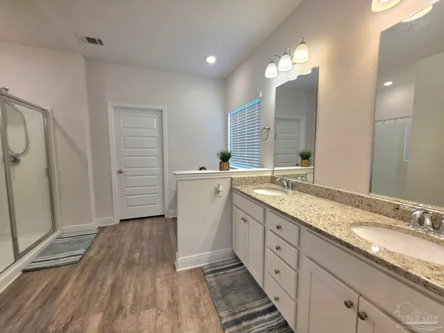 a spacious bathroom with a double vanity sink and a mirror