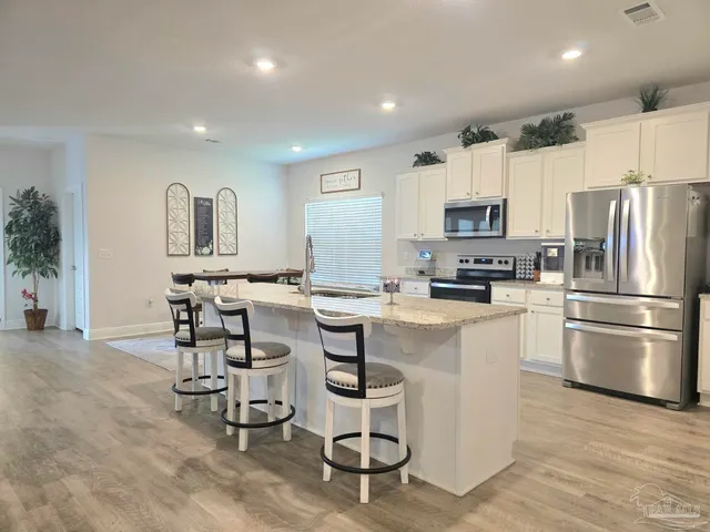 a kitchen with kitchen island a counter top space cabinets and stainless steel appliances