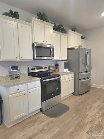 a kitchen with granite countertop a sink stainless steel appliances and cabinets