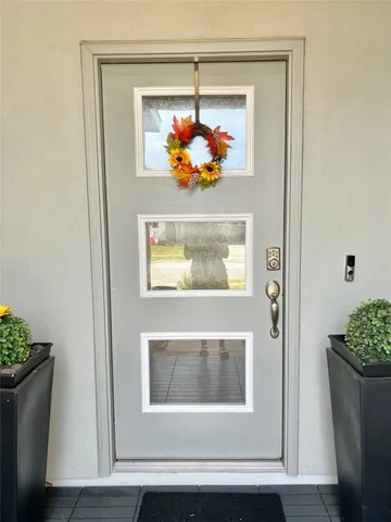 a view of a hallway with wooden floor and a potted plant