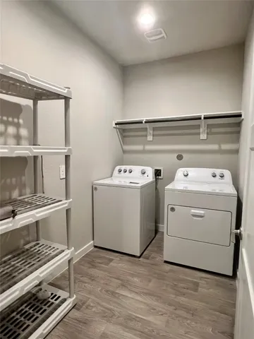 a utility room with dryer washer and wooden cabinets