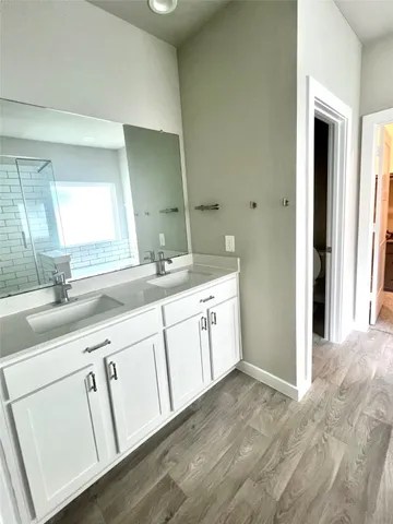 a spacious bathroom with a double vanity sink and mirror