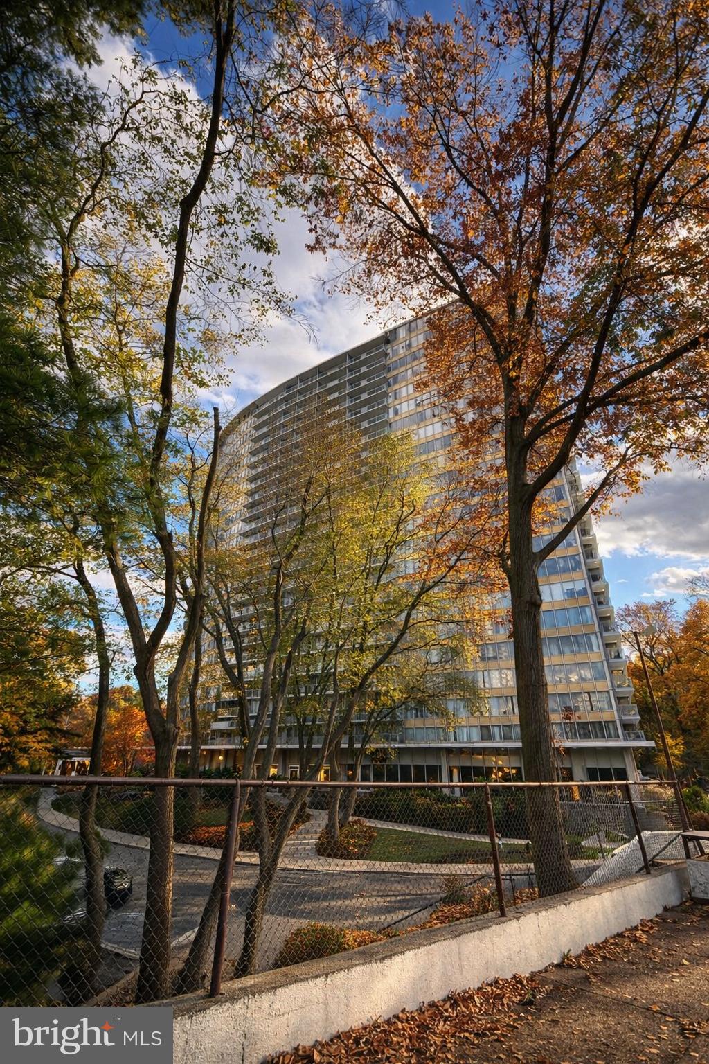 3900 West Ford Road, Unit 9K Philadelphia, PA 19131 - Photo 2 of 17 a view of backyard with wooden fence and large trees