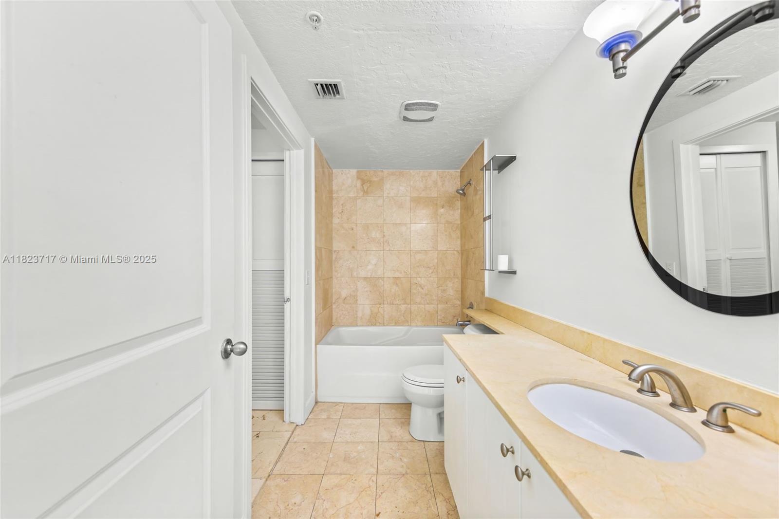 170 Southeast 14th Street, Unit 1203 Miami, FL 33131 - Photo 16 of 24 a bathroom with a sink a toilet and a mirror