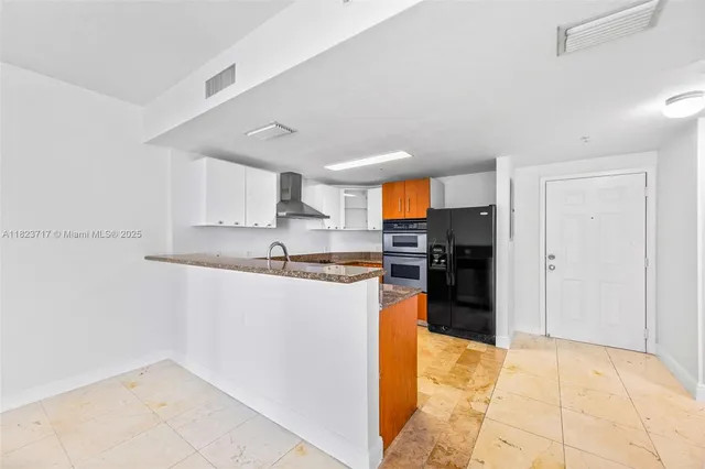 a kitchen with stainless steel appliances granite countertop a refrigerator and a sink