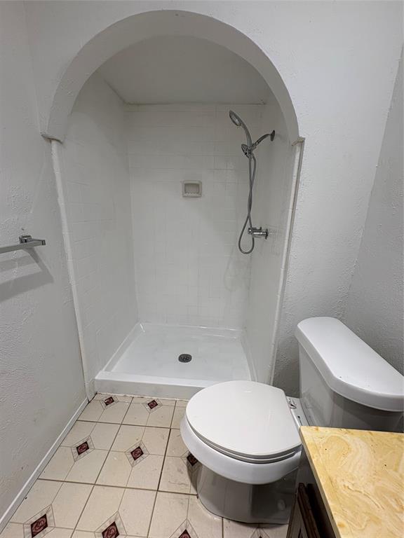 7226 Little Canyon Road Dallas, TX 75249 - Photo 20 of 30 a bathroom with a toilet and a shower