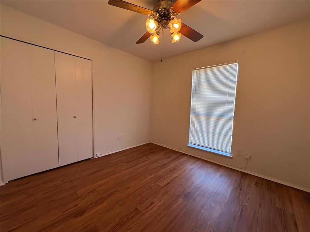 7226 Little Canyon Road Dallas, TX 75249 - Photo 21 of 30 an empty room with wooden floor fan and windows