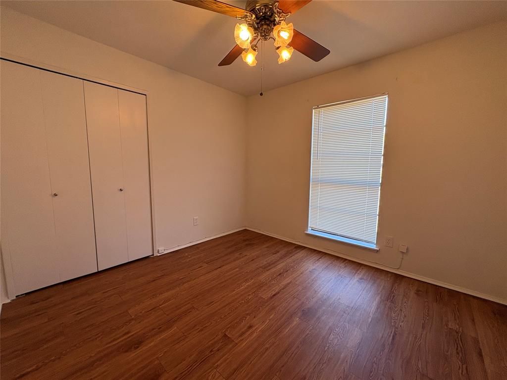 7226 Little Canyon Road Dallas, TX 75249 - Photo 22 of 30 a view of an empty room with wooden floor and a window