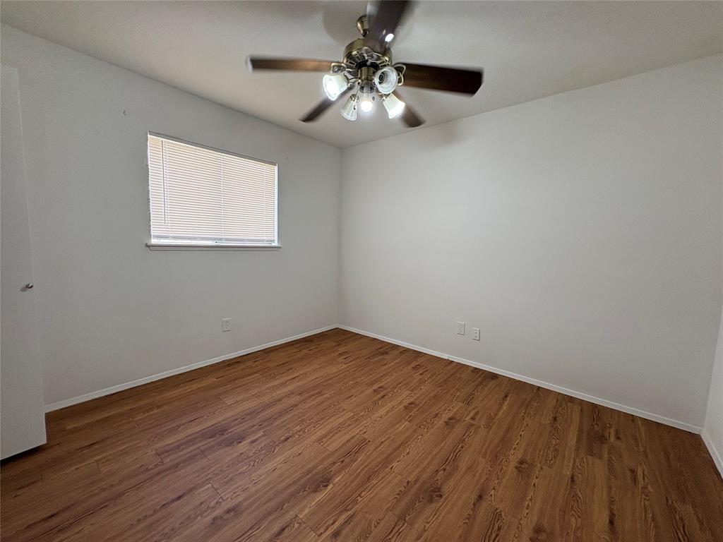 7226 Little Canyon Road Dallas, TX 75249 - Photo 24 of 30 a view of an empty room with wooden floor