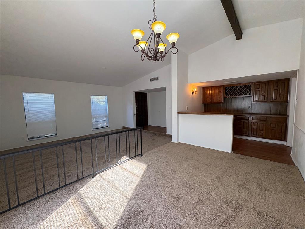 7226 Little Canyon Road Dallas, TX 75249 - Photo 6 of 30 a hallway with a chandelier and kitchen view