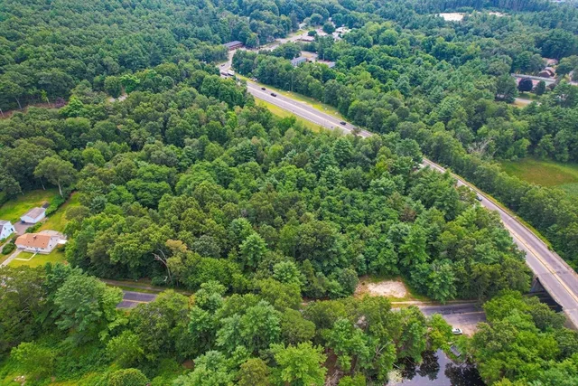an aerial view of residential houses with outdoor space and trees