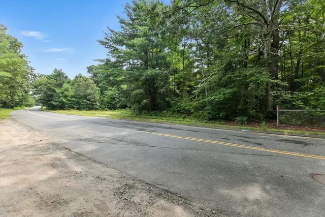 a view of a field with trees in background