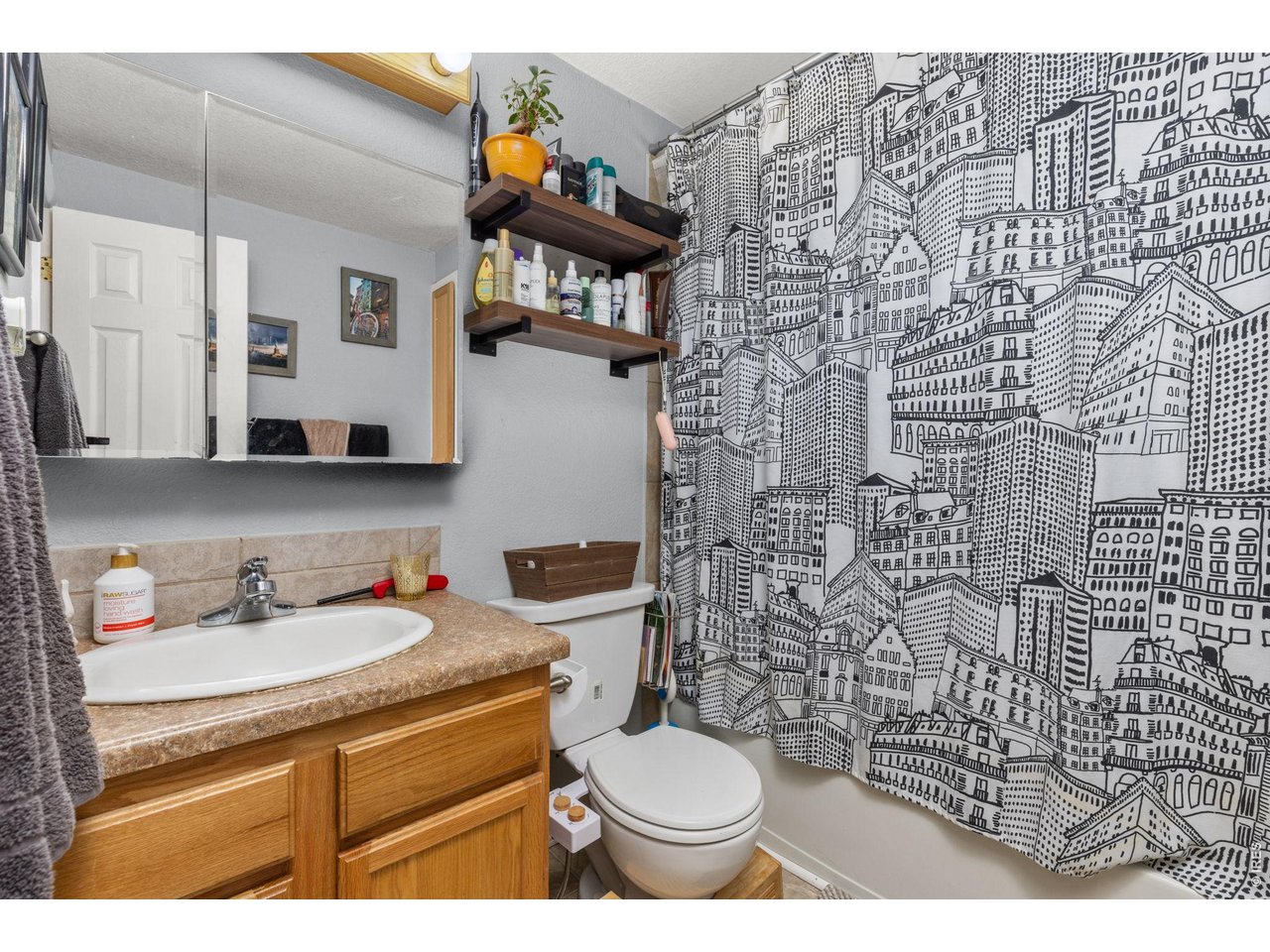 4653 Dover Street Wheat Ridge, CO 80033 - Photo 14 of 20 Main bath has a double sided medicine cabinet and some shelves for extra storage